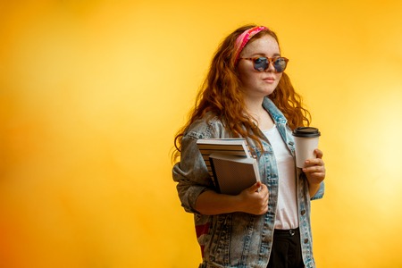 Portrait of funny cheerful redhead girl wearing big pink glassesの写真素材
