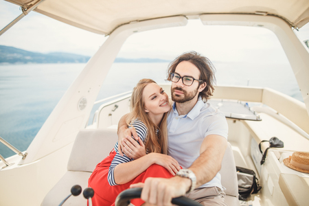 Young beautiful married couple embracing on the yacht on vacationの写真素材