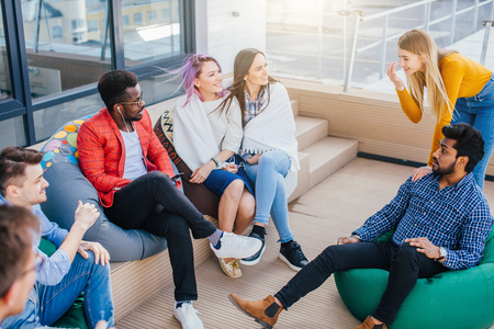 People discussing working process while sitting at the office lounge outdoorの写真素材