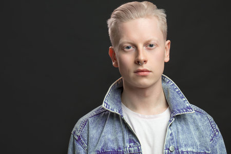 Handsome blonde american man in denim jaket isolated over black backgroundの写真素材