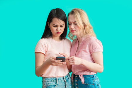 Angry irritated young business woman holding mobile phone and glases and shouting over white...
