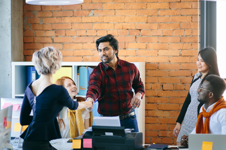 Hindu leader in casual outfit is making acquaintance with blond colleagueの写真素材