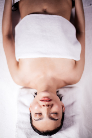 young nice woman lying on the bed after getting a renewing herbal rub-downの写真素材