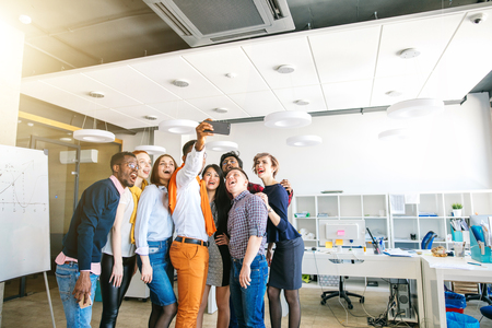 joyful stylish employees taking picture of themselves.の写真素材