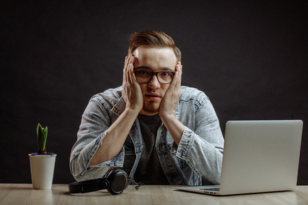 astonished man in casual outfit with hands on cheeks,の写真素材
