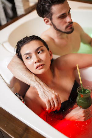 pensive girl lying in the whilpool with her friendの写真素材