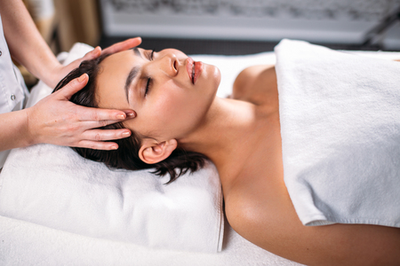 facial cleansing treatments. young lady getting massage for faceの写真素材