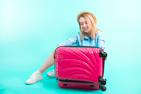 cheerful girl is going to close her baggageの写真素材