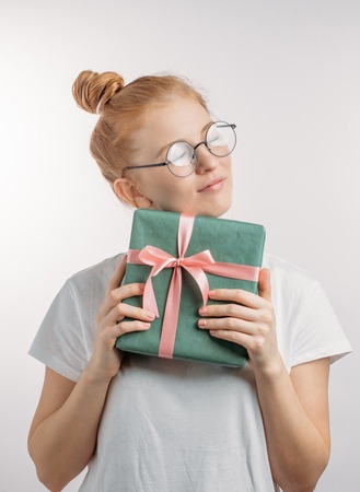 girl with tender look is trying to understand what is in the boxの写真素材