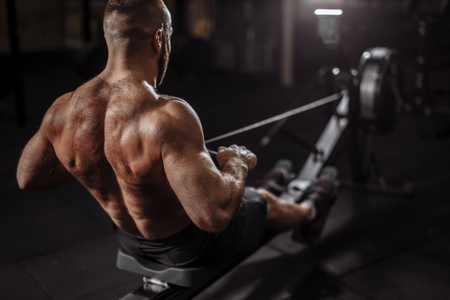 close up back view photo. shirtless male using training simulation in the clubの写真素材