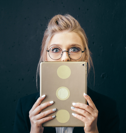close up portrait of blond corporate woman closing her mouth with tablet.の写真素材
