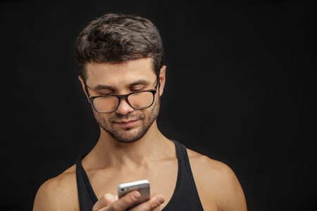 Fit young man using mobile phone.の写真素材