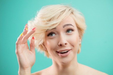 Awesome caucasian funny fair-haired girl is touching her fringの写真素材