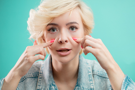 Skin care . Beauty woman is showing her gray eyea to the eye specialistの写真素材