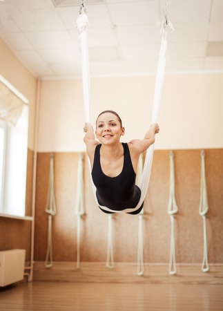 joyful pleasant fit woman is flying on the white hammockの写真素材