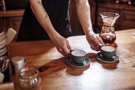 close up photo of barista holding empty cupsの写真素材