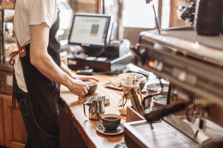 salesman is making espresso for clients in the coffee houseの写真素材