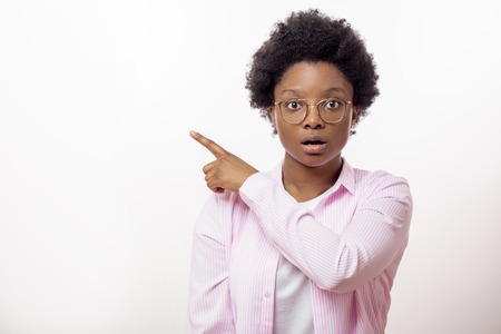 astonished, scared woman indicates at somewhereの写真素材