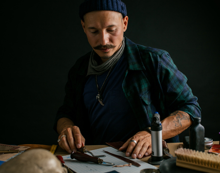 Shoemaker is repairing shoe. Shoemaker sews shoes. Cobbler workshop.の写真素材