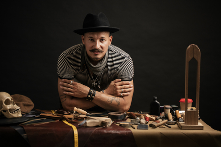 Craftsman posing on his working place with crafting toolsの写真素材