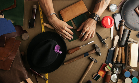 Close-up. Male hand master cut with a knife to skin products. Small businessの写真素材