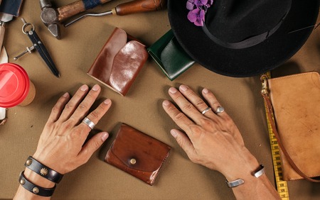 Leather goods master and handmade leather wallets. Workflow in the workshop.の写真素材