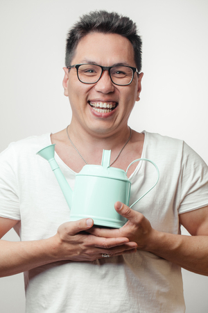 Happy funny Asian man in his 30s in white usual t-shirt with different positive emotionsの写真素材