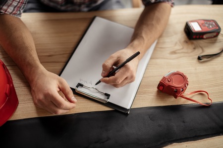 design study concept. top view photo. man's arms writing something on the clipboard. documentationの写真素材