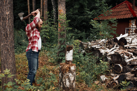 Woodcutter in shirt chopping firewoods, chips fly apart