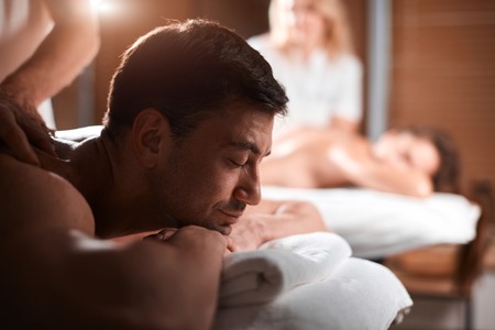 Young couple receiving a back massage in a Spa centerの写真素材