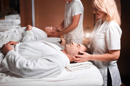 Man receiving back massage from masseur in spa