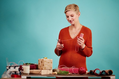 Professional designer holds gift and wrapping paper in hand.の写真素材