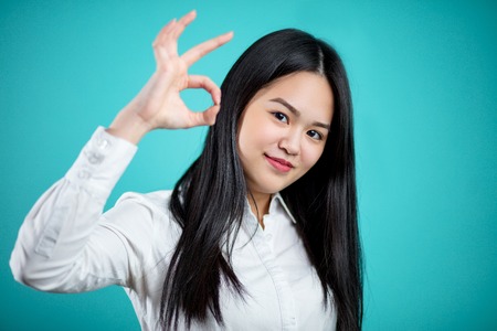 Beautiful young Asian woman isolated on blue background. Facialの写真素材