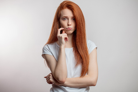 Portrait of displeased attractive redhaired woman isolated overの写真素材