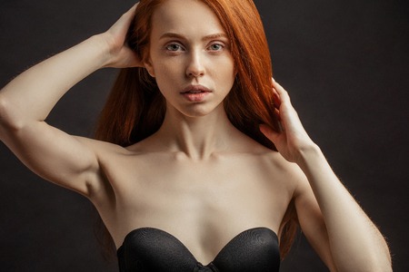 Slim young sex appealing girl with long gorgeous red hair on blaの写真素材