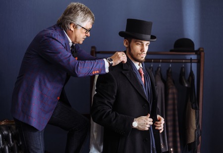 Tailor with client in atelier. Sewing custom made suitの写真素材