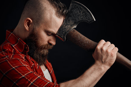 lumberjack. Confident bearded man attached to forehead axe