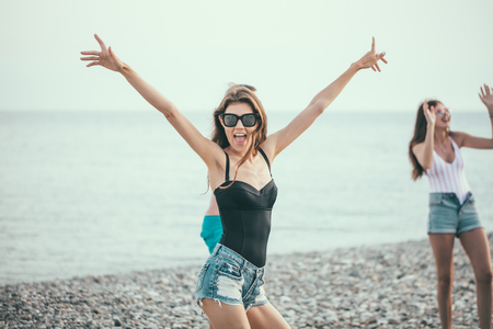 young slim beautiful woman on beach, playful, dancing, summer vacation, having fun, positive mood, happyの写真素材
