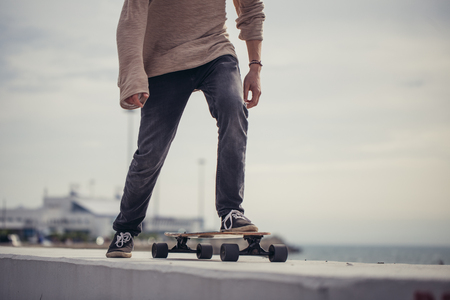 Close up of man foot riding longboard in parkの写真素材