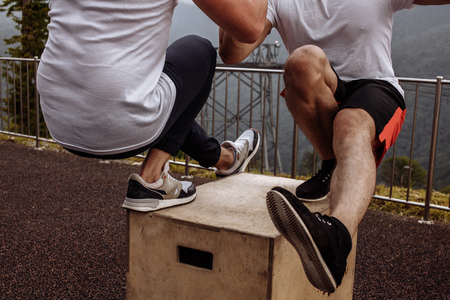 Musculat guys showing one leg squat exercise, close up, outdoor workoutの写真素材