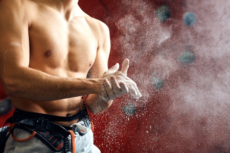Climber coating his hands in powder chalk magnesium to climb indoor, close-upの写真素材