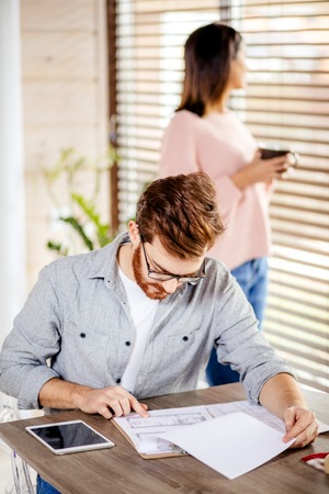 Young couple watching video online in a tablet relaxing home together.の写真素材