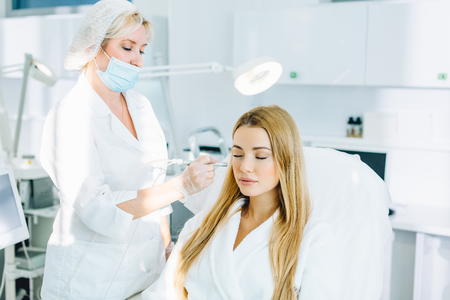 Blonde woman undergoes a procedure of facial gas-liquid oxygen peelingの写真素材