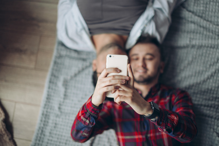 gay couple making selfie in bedの写真素材