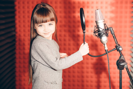 smiling beautiful girl looking at the camera in the music studioの写真素材