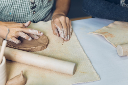 little child making handicraft with dough on the tableの写真素材