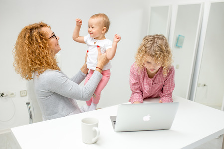 happy young ginger woman holding a baby and playing with him,の写真素材