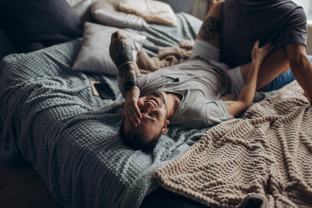 Two sexy caucasian gay guys hugging and having fun in bed indoors