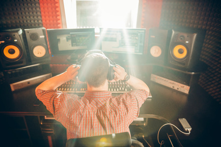 man listening to music while sitting in the studioの写真素材
