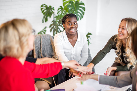 Happy multiracial business women celebrate success or expressing aproval in office